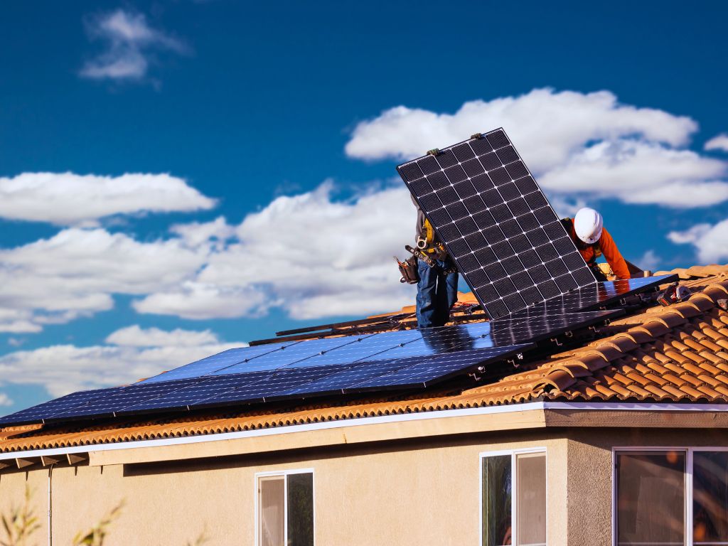 Technician installing rooftop solar panels in Bundaberg suburb